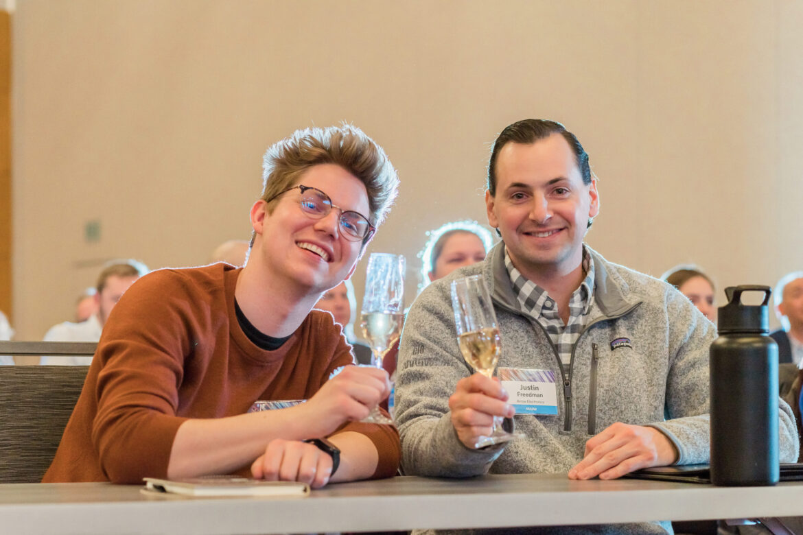 Two conference attendees networking and laughing at Denver corporate event