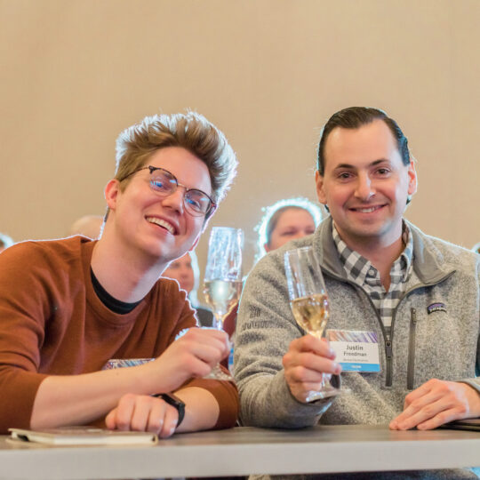 Two conference attendees networking and laughing at Denver corporate event