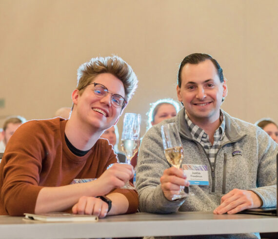 Two conference attendees networking and laughing at Denver corporate event