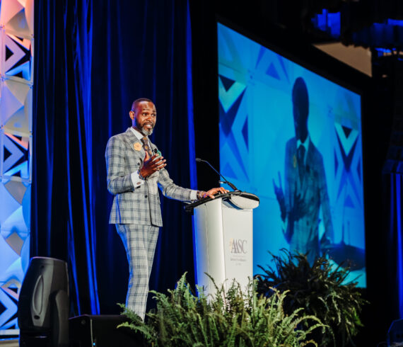 Professional conference headshot portrait with blue stage lighting background