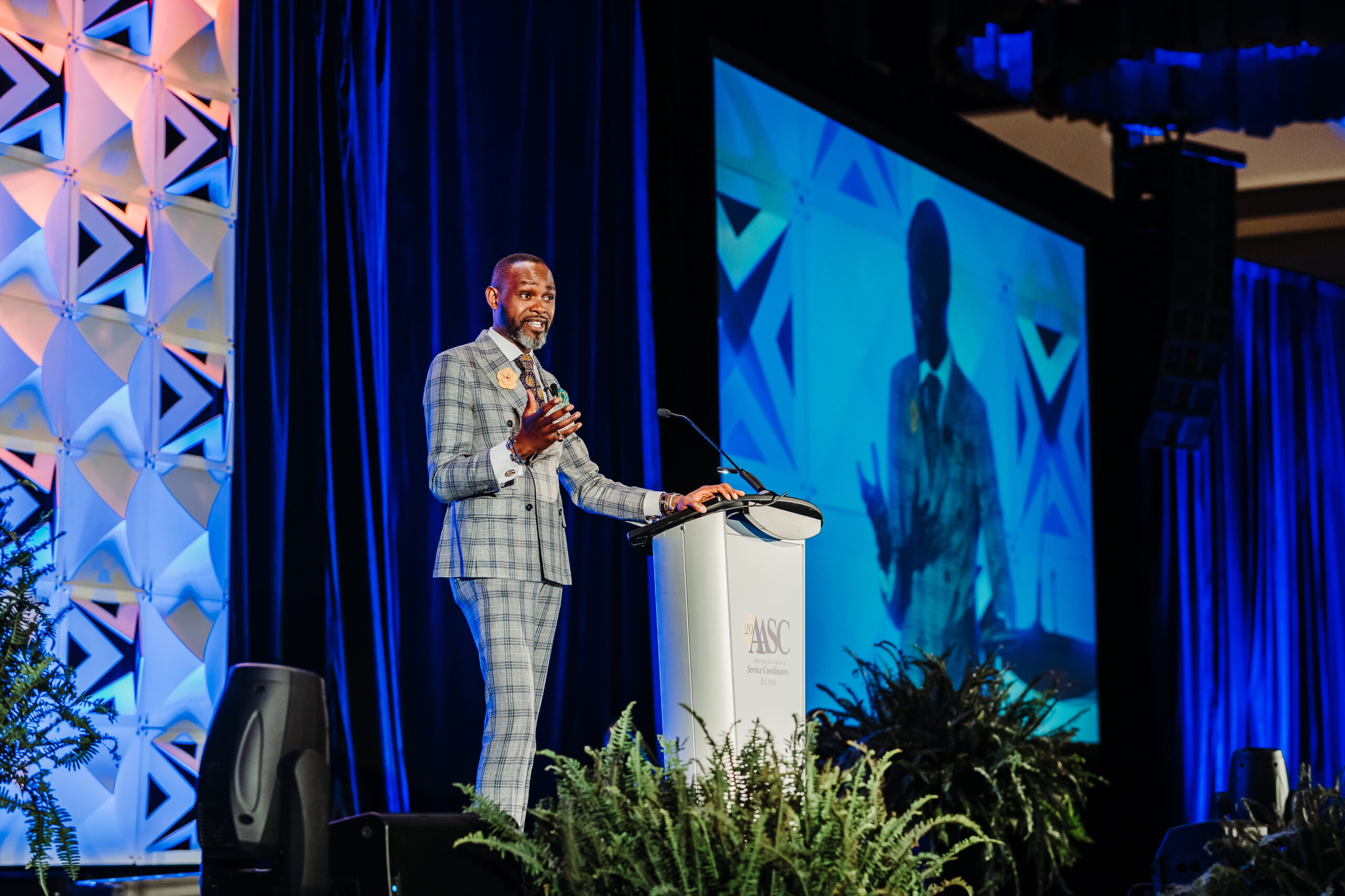 Professional conference headshot portrait with blue stage lighting background