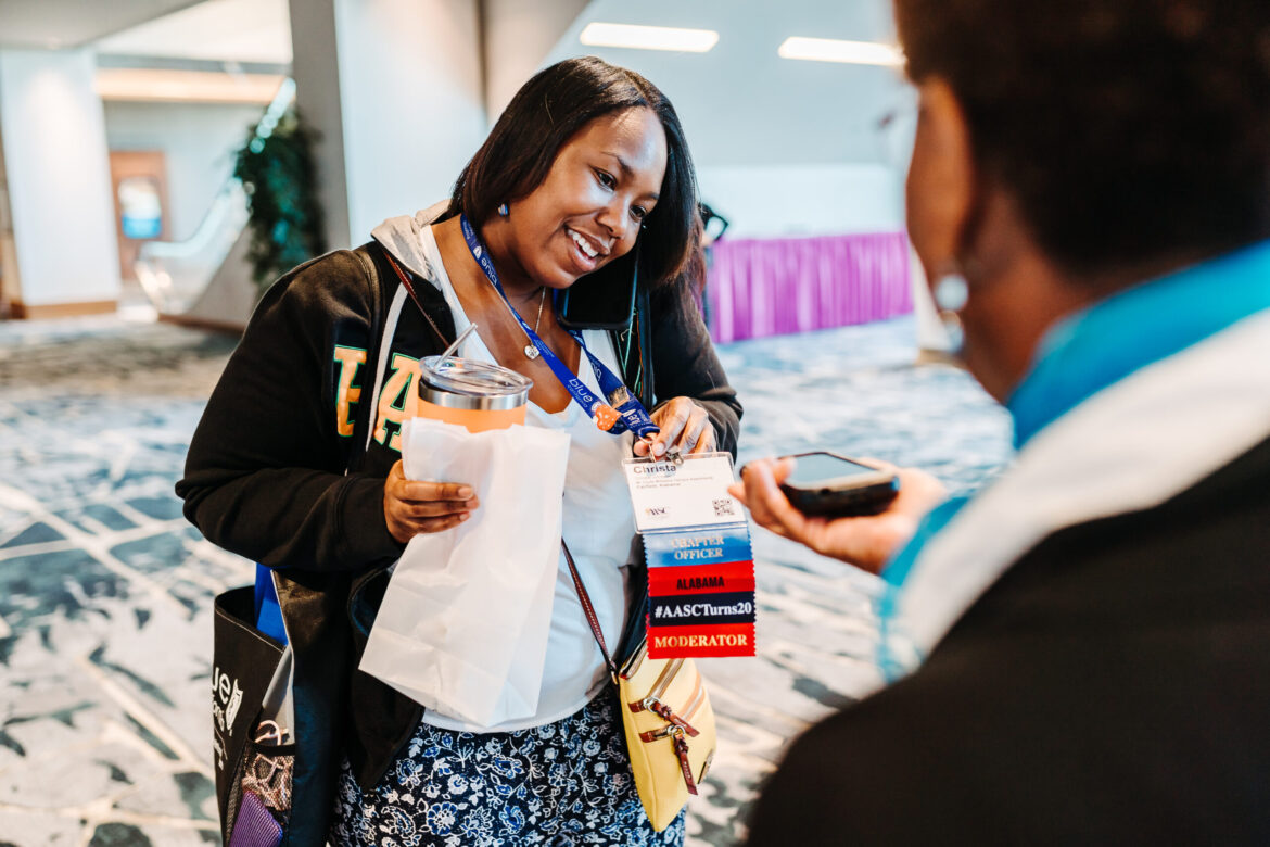 Conference attendee badge closeup showing event branding and sponsor visibility