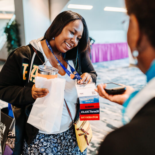 Conference attendee badge closeup showing event branding and sponsor visibility