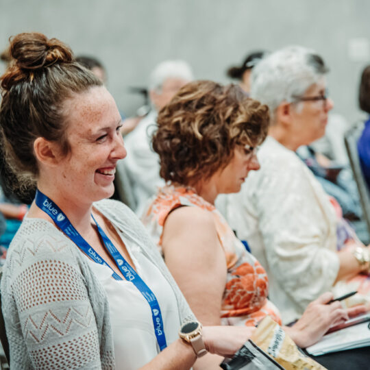 Conference attendees smiling during event session in Denver